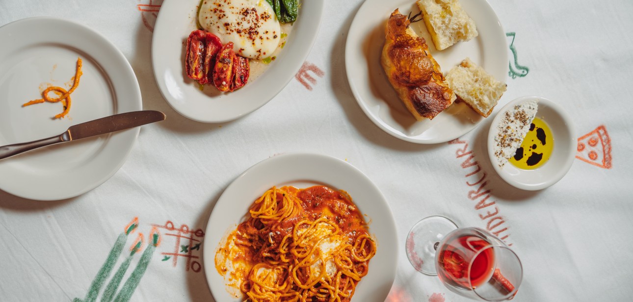 A round of burrata with grilled peppers, tomato on focaccia and a plate of spaghetti in tomato sauce